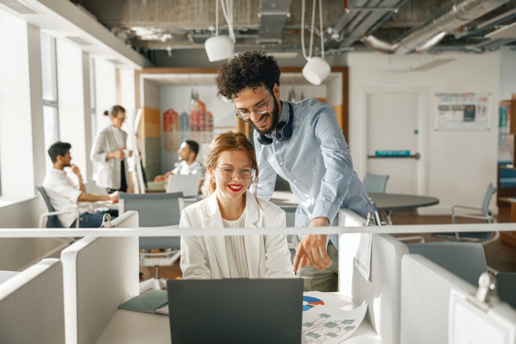 businesspeople working together in bright office sitting at desk